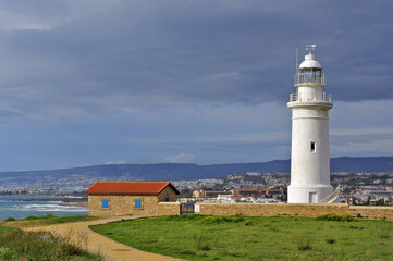 Fototapeta na wymiar Lighthouse on the coast of state country. View of the lighthouse and Paphos in early spring.
