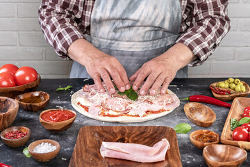 Pizza preparation with chef hands. Cutting pizza