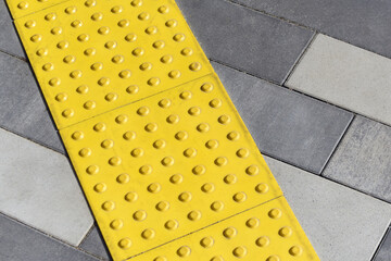 Yellow blocks of tactile paving for blind handicap. Braille blocks, tactile tiles for the visually...