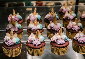 Pink and blue unicorn cupcakes in golden cups