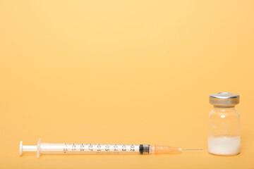 Syringe and ampules on yellow background.Vaccination.