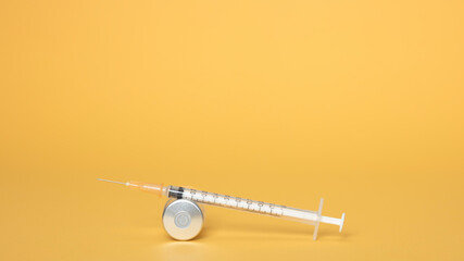 Syringe and ampules on yellow background.Vaccination.