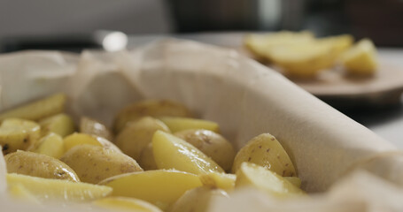 pour boiled potatoes in a container with baking paper