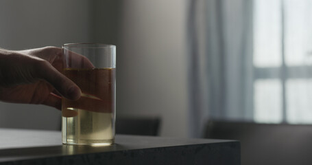 man take soda drink in highball glass from concrete countertop with copy space