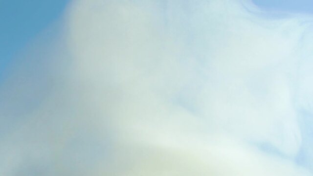 Smoke on a blue background. White fog against the sky. Formation of clouds in the sky. Slow motion. Intro, outro.Footage, the texture of the smoke. Equalizer, video effect. Contemplation, meditation.