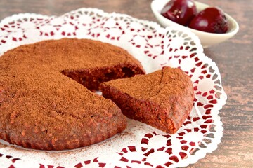 Beetroot chocolate cake with cacao powder on wooden background