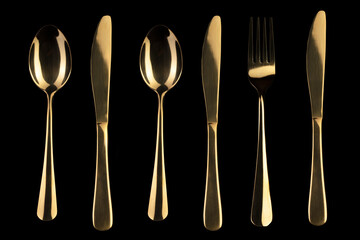 Gold knife and spoon and fork on a black background. Cutlery.