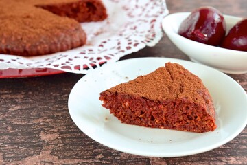 Beetroot chocolate cake with cacao powder on wooden background