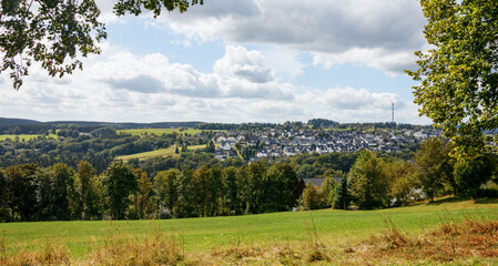 Fototapeta na wymiar Panoramic view of Winterberg and the surrounding forests and hills on a sunny day in summer. Hochsauerland, North Rhine-Westphalia, Germany.