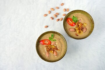 Borlotti bean or cranberry bean soup garnish with caramelized onion, chili and parsley