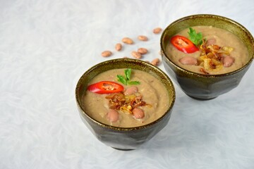 Borlotti bean or cranberry bean soup garnish with caramelized onion, chili and parsley