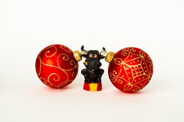 The bull is the symbol of the New year 2021 on white background. Happy New year. Christmas balls hang on the horns of a black bull