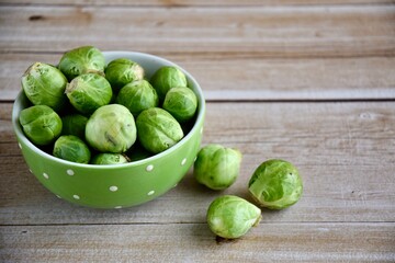 Fresh Brussel Sprouts in a bowl on wooden background