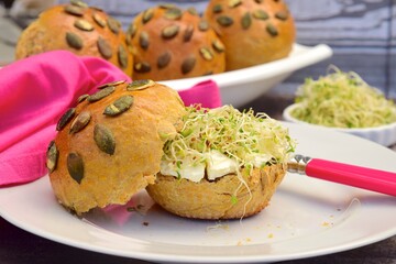 pumpkin seed bread bun with cream cheese and sprouts
