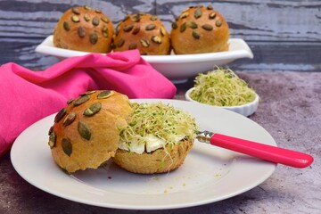 pumpkin seed bread bun with cream cheese and sprouts
