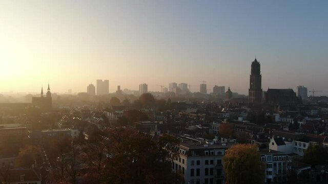 Cinematic 4k aerial video of historic Utrecht city center with the Dom Church with foggy golden light and fall colours