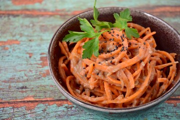 Fresh raw organic spiralized carrot noodle with tahini, parsley and sesame seeds