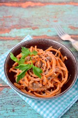 Fresh raw organic spiralized carrot noodle with tahini, parsley and sesame seeds