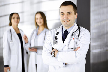 Fototapeta premium Professional middle aged doctor with a stethoscope at work with colleagues in a clinic. Perfect medical service in a hospital. Medicine and healthcare concept