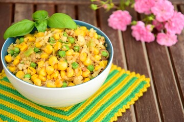 Cauliflower rice with corn and peas garnish with basil leaf