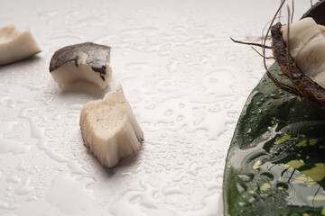 Pieces of chopped coconut close up on white table, close up