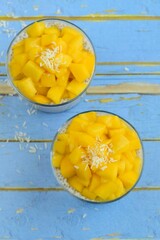 Coconut mango chia seed pudding. Blue background