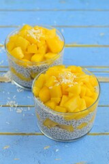 Coconut mango chia seed pudding. Blue background