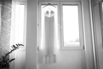 Brautkleid hängt an einem Kleiderbügel vor einem Fenster, Deutschland