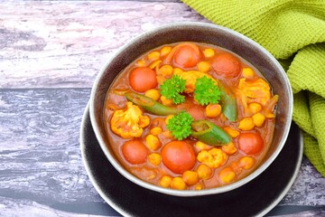 Spicy chickpea cauliflower tomato soup with green chili and parsley
