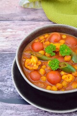 Spicy chickpea cauliflower tomato soup with green chili and parsley
