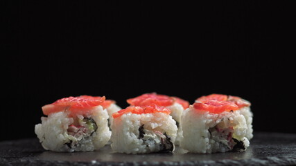 Lunch at a Japanese restaurant. Man eating sushi. Philadelphia sushi from fish, salmon, rice, cucumber. Sushi restaurant, sushi delivery. Selective focus