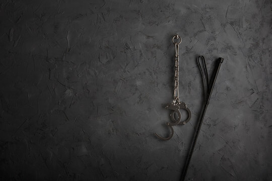 An einer Wand befestigte Handschellen mit Gerte