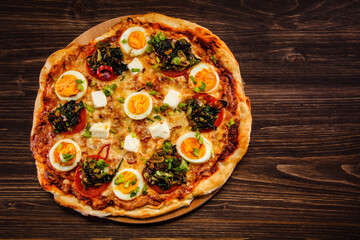 Pizza pepperoni with hard boiled eggs on wooden table
