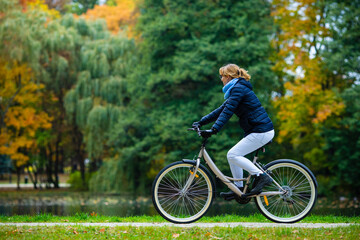 Urban biking - woman riding bicycle in city park