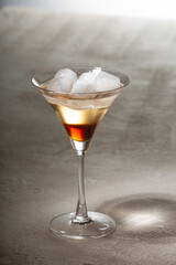 Alcoholic drink with ice on a light table, copy space