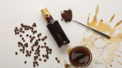 Coffee concept with coffee in cup, coffee beans and irish cream syrup isolated on white background, top view