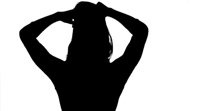 Silhouette. Professional dancer performs over white background, medium shot.
