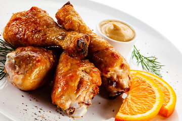 Barbecue chicken drumsticks with vegetables on white background

