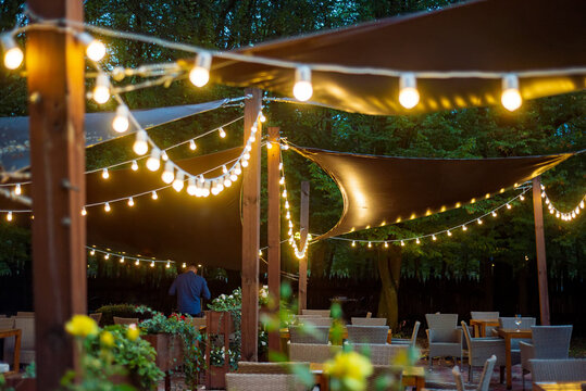 A gazebo decorated with garlands on a warm summer evening