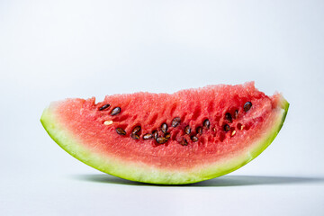 Watermelon on a white background. Cut off a slice of watermelon. Red ripe watermelon