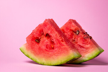 Watermelon on a pink background. Cut off a slice of watermelon. Red ripe watermelon