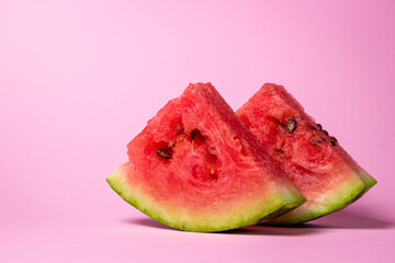 Watermelon on a pink background. Cut off a slice of watermelon. Red ripe watermelon