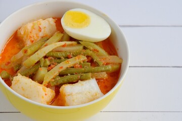 Lontong Sayur, Indonesian cuisine. Compressed rice cake or lontong with vegetables (chayote and yard long beans) cooked in coconut milk and spices. Served with boiled egg and emping cracker