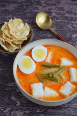 Lontong Sayur, Indonesian cuisine. Compressed rice cake or lontong with vegetables (chayote and yard long beans) cooked in coconut milk and spices. Served with boiled egg and emping cracker