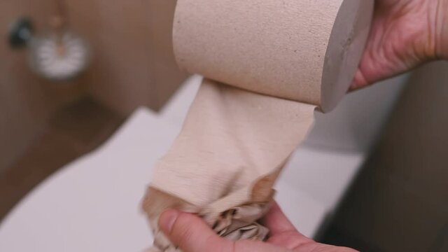 Female Hands Reel In And Tear A Piece Of Toilet Paper. Close-up. Slow Motion