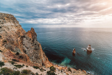 Autumn sea landscape with overcast sky and volcanic rocky coastline. Calm sea on a background of...