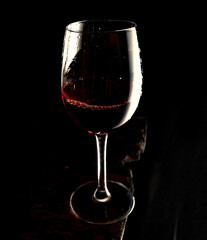 Red wine in glass on dark old board, copy space