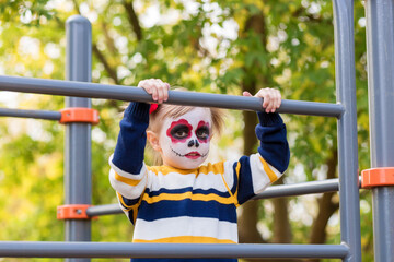 Obraz premium A littlel girl with Painted Face, looking at camera on Mexican Day of the Dead