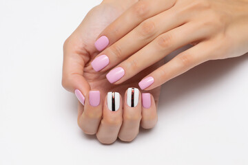 Light pink manicure with white marigolds and a black shiny strip on short square nails close-up on a white background