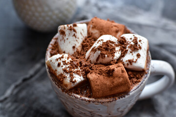 Hot chocolate and marshmallows. Hot Cocoa in a white cup. Dark background. Autumn drink concept. Copy space.